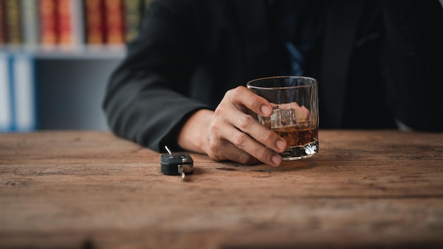 Homme tenant un verre de cognac, il boit du cognac dans un bar boire de l'alcool nuit à la capacité de conduire et peut nuire à la santé Le concept de la consommation d'alcool