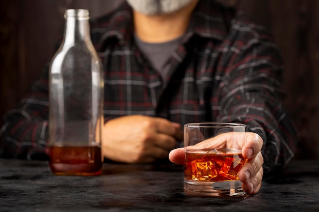 Homme tenant un verre à whisky