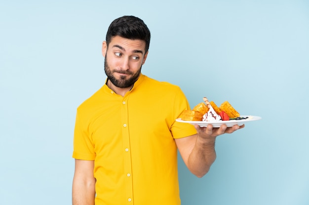 homme, tenue, gaufres, isolé, sur, bleu, à, expression triste