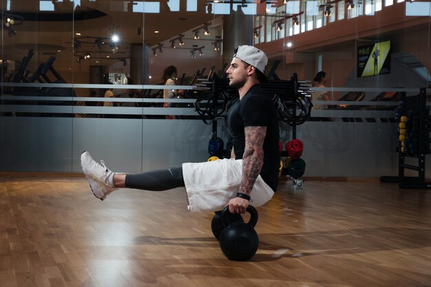 Homme En Tenue De Sport S'entraîne Dans La Salle De Gym