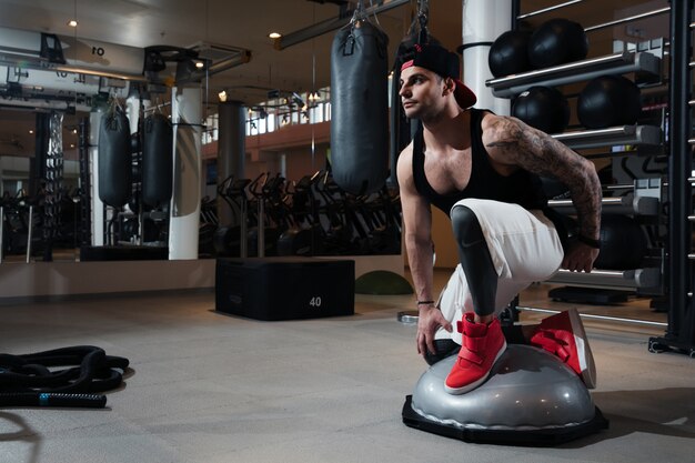 Homme En Tenue De Sport S'entraîne Dans La Salle De Gym