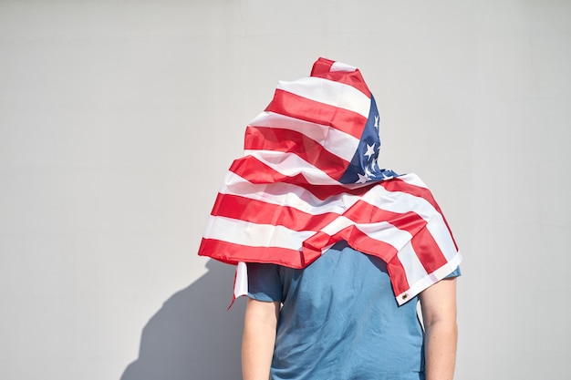 Homme à tête enveloppée dans le drapeau des Etats-Unis.