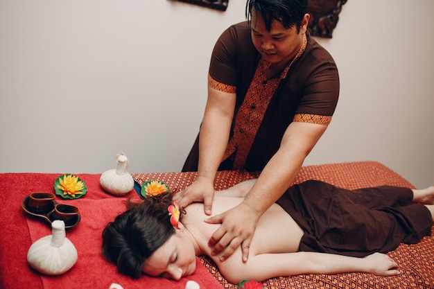 Photo homme thaïlandais faisant une procédure de massage thaïlandais classique à une jeune femme au salon de beauté spa