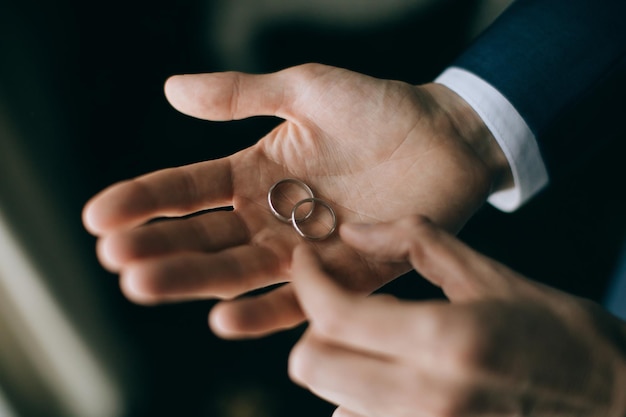 Photo l'homme tient une alliance en or accessoires de mariage