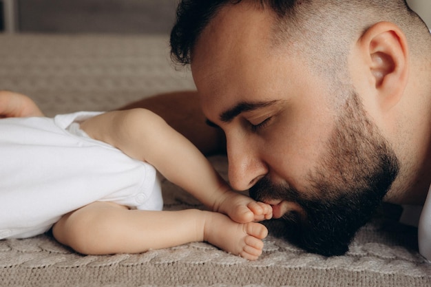 un homme tient un bébé et dort sur le sol