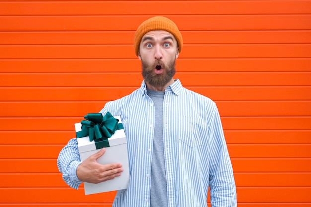 L'homme tient une boîte blanche avec un arc vert