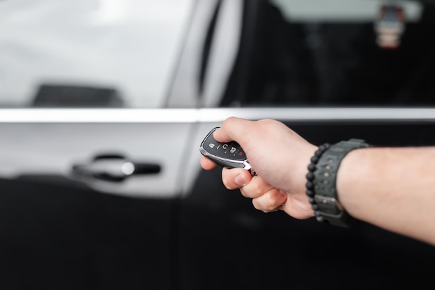 Photo l'homme tient les clés et ouvre la voiture location de voiture et essai de conduite