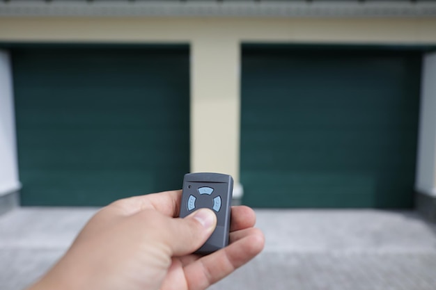 L'homme tient dans sa main une télécommande qui ouvre la porte du garage