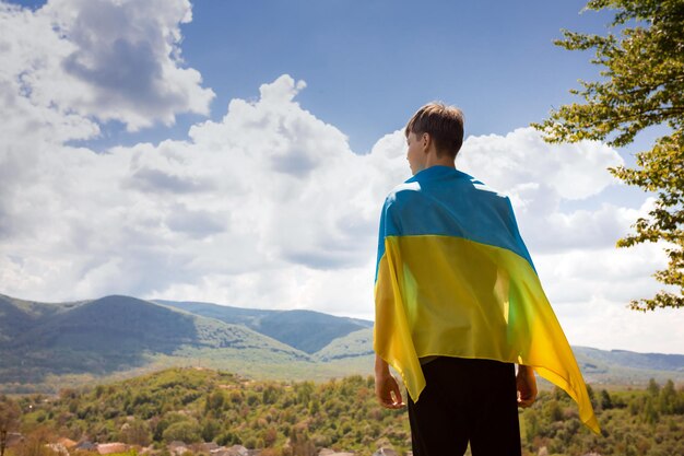 Un homme tient le drapeau ukrainien Arrêtez la guerre sur fond de montagnes