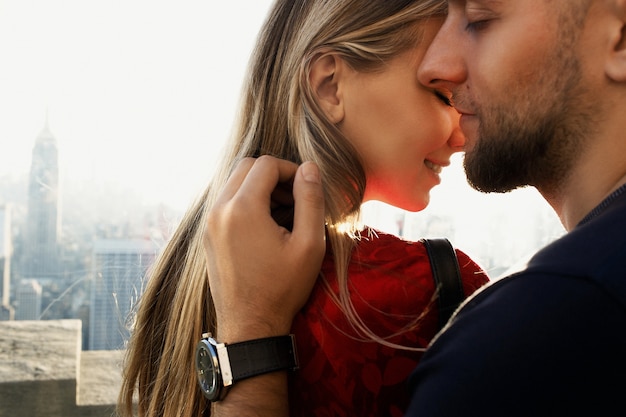 Photo homme tient la femme tendre debout devant une belle vue sur new york derrière la fenêtre