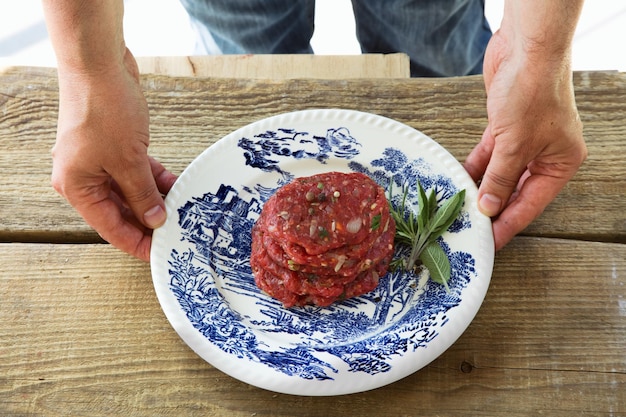 L'homme tient des hamburgers pour le BBQ