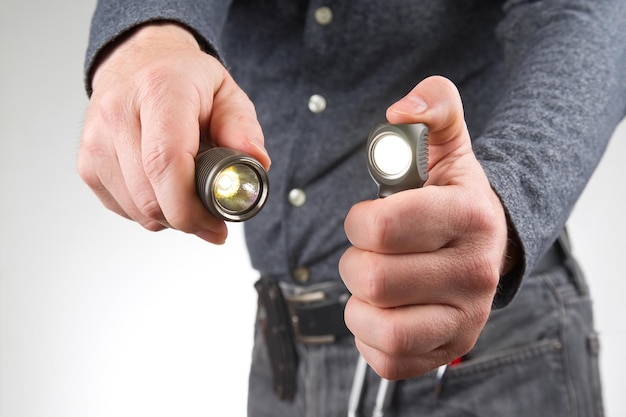 L'homme tient une lampe de poche dans sa main pour le camping et la vie de famille