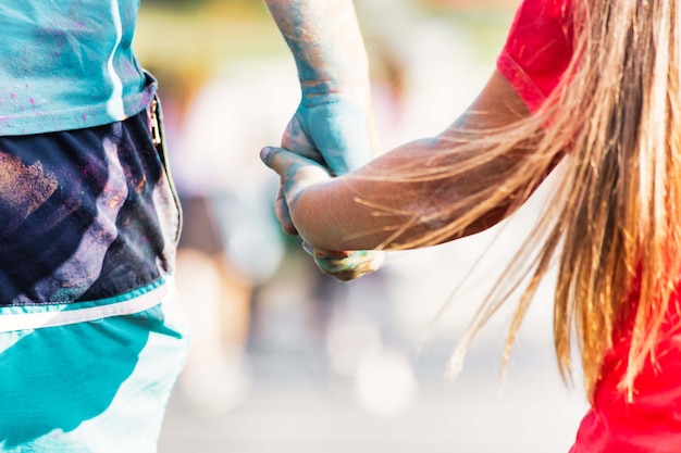 Photo un homme tient la main d'une femme pendant le festival des couleurs