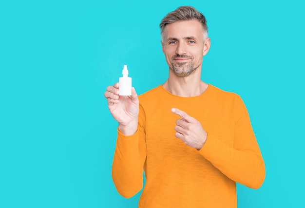 L'homme tient la médecine nasale sur l'arrière-plan point doigt photo de l'homme tient la médecine nasale