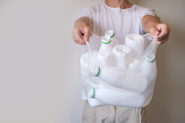 L'homme tient et montre un sac avec beaucoup de bouteilles en plastique, recyclage des déchets, concept écologique