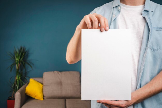 L'homme tient un morceau de papier blanc