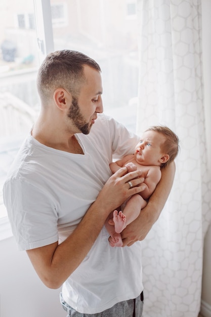 Un homme tient une petite fille à la maison.