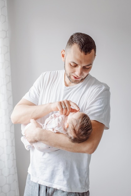 Un homme tient une petite fille à la maison.