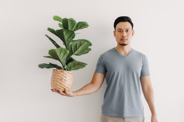 L'homme tient une plante d'intérieur isolée sur blanc