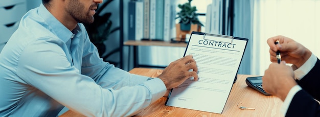 Photo un homme tient un presse-papiers avec le mot contrat dessus.