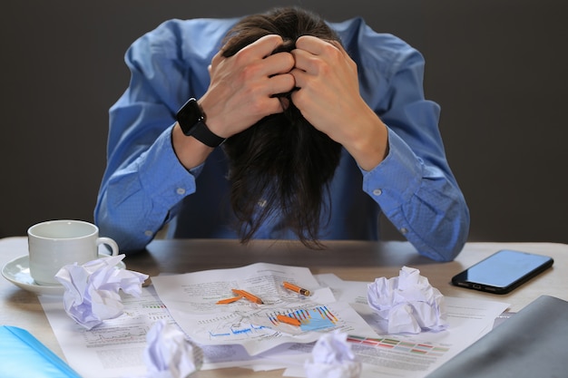 L'homme tient sa tête. Échec au travail