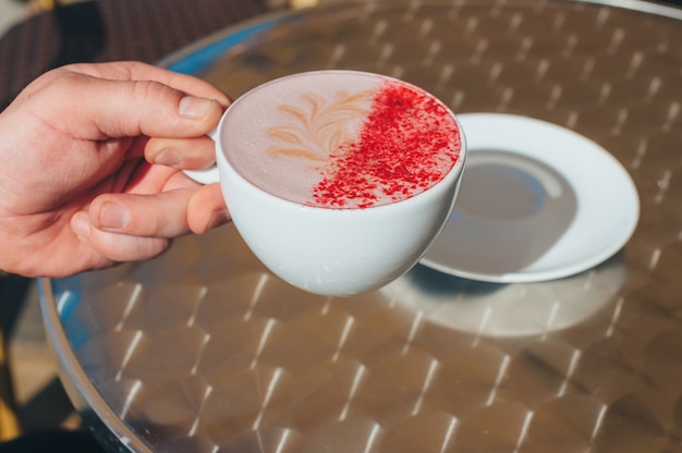 Un Homme Tient Une Tasse De Café Au Restaurant.