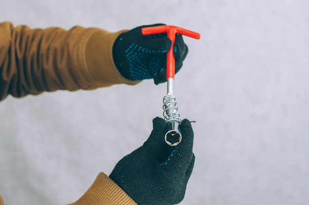 Un homme tient un tournevis de construction dans ses mains sur une lumière.