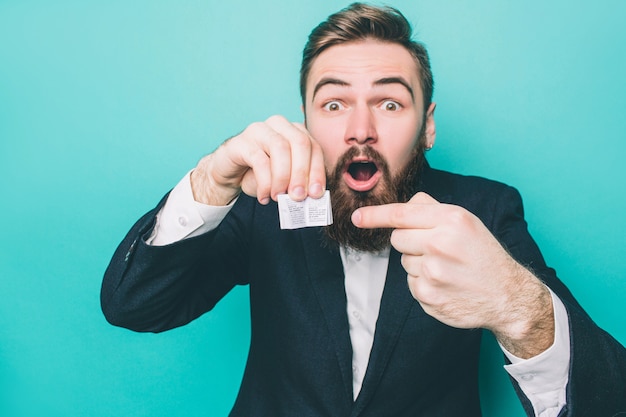 Photo l'homme tient un très petit livre et le pointe dessus