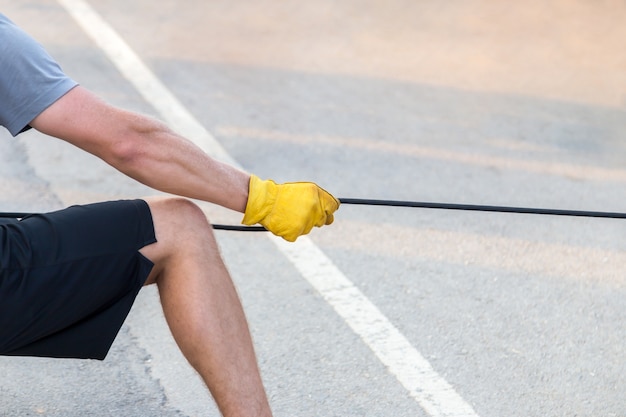 Homme Tirant La Corde Avec Un Gant Jaune