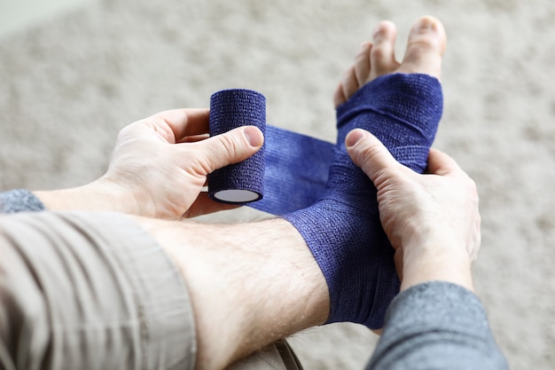 L'homme tire sur sa jambe avec un bandage élastique