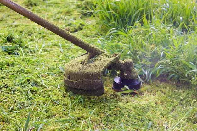 Un homme tond la pelouse avec une tondeuse