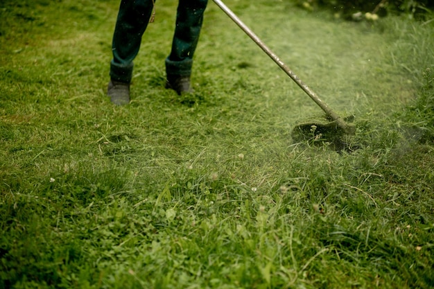 Homme tondant l'herbe, la tondeuse se bouchent.