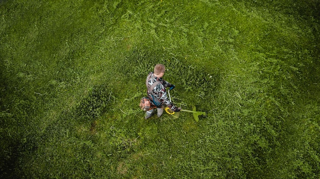 L'homme tondeuse tond la pelouse la vue du haut