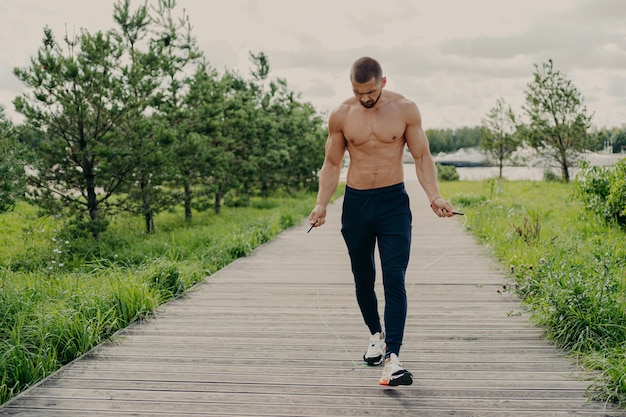 Photo homme torse nu travaillant à l'extérieur avec corde à sauter