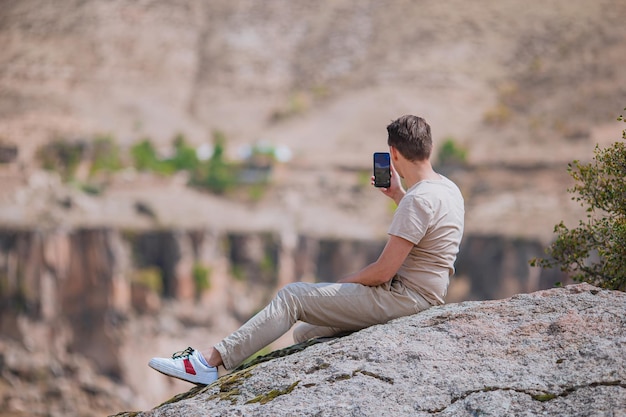 Homme de tourisme en plein air au bord du bord de mer de la falaise