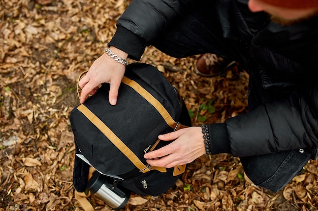 Homme de touristes regardant dans son sac à dos Concept de voyage Paysage d'arrière-plan d'automne