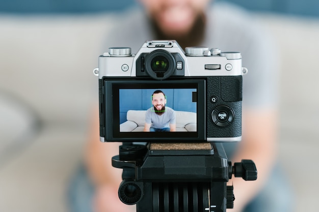 homme tournage vidéo de lui-même à l'aide de l'appareil photo sur trépied concept de technologie et d'équipement moderne.