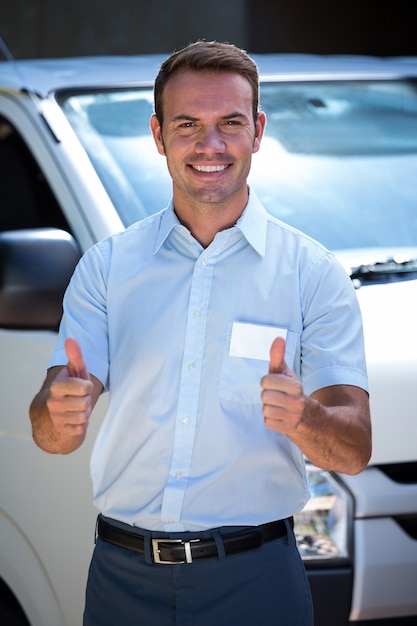 Homme à tout faire debout près de sa camionnette de livraison