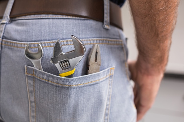 Homme à tout faire avec des outils dans la poche arrière