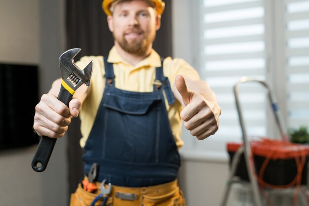 Homme à tout faire positif montrant l'outil de travail