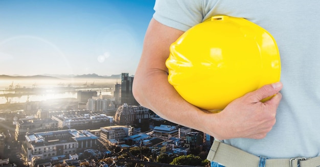 Homme à tout faire tenant un casque contre le paysage urbain