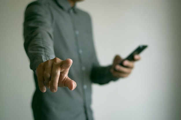 Un homme en train de discuter sur son téléphone portable et de pointer un doigt.