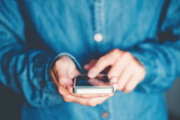 Homme en train de taper un message téléphonique sur un réseau social