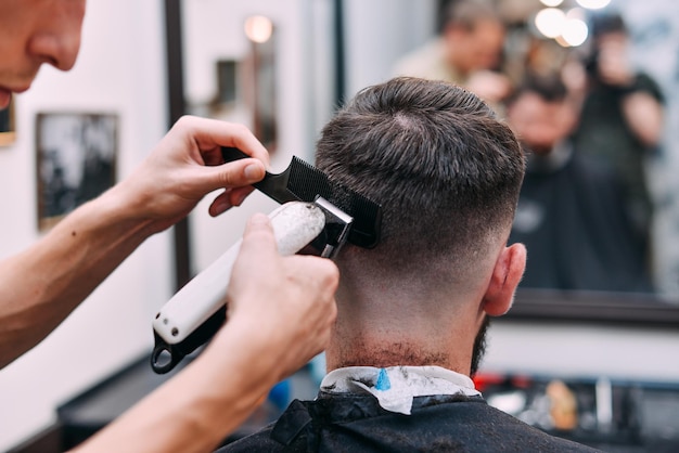 Un homme traîne dans un salon de beauté. Coupe de cheveux et coiffage en salon de coiffure. Soins pour hommes pour la barbe et les cheveux.