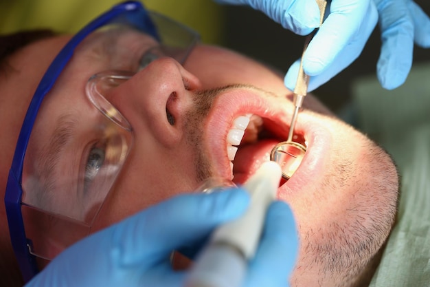 Un homme traite des dents un plan rapproché calme de visage de patients