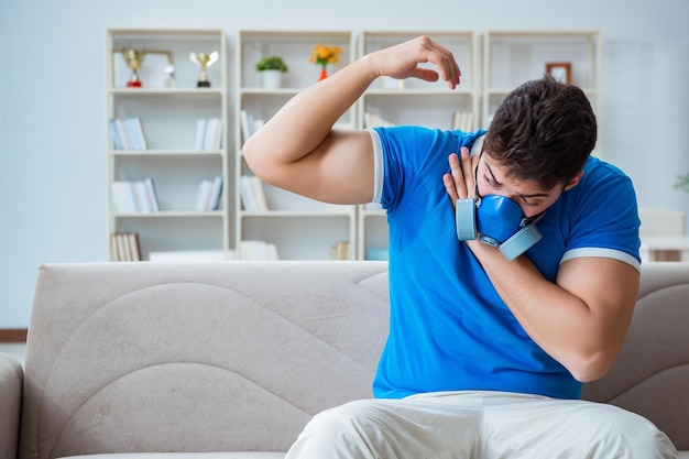 Homme transpirant excessivement sentant mauvais à la maison