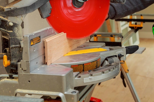 Homme de travail de charpentier à l'aide d'une scie circulaire couper du bois