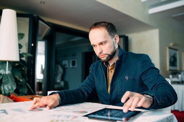 Homme travaillant au bureau et analysant certains rapports de calcul statistique.