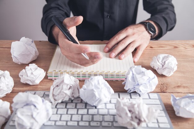 Homme travaillant au bureau. Boules de papier froissé sur la table