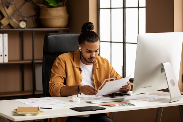 Photo homme travaillant au bureau coup moyen